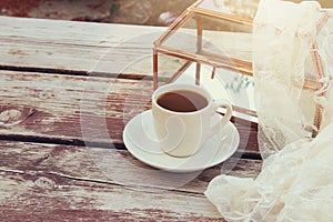 cup of coffee on old wooden table outdoor in the park