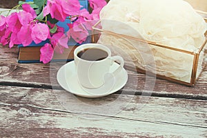 cup of coffee on old wooden table outdoor in the park