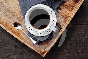 Cup of coffee on old wooden tray background