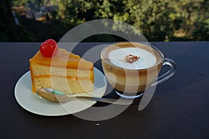 A cup of coffee with orange cake