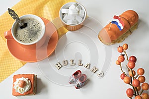 Cup of coffee, orange cake and eclair. Traditional treat for Dutch event Kings Day, Koningsdag