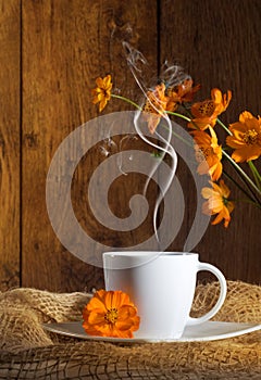 Cup of coffee with orange flowers