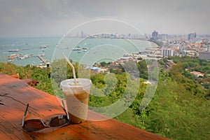 A cup of coffee with Pattaya beach view in sunny.