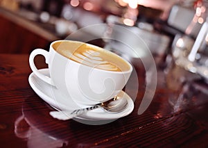 A cup of coffee with a pattern on a foam or latte-art close-up on