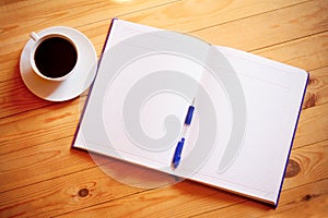 Cup of coffee, pen, opened organizer