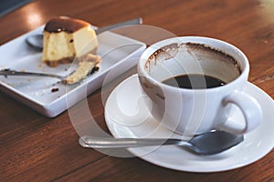 A cup of coffee and a piece of cake on table