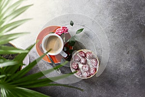 Cup of coffee and a pink rose on a light kitchen table in the ray of sunlight. Top view with copy space for your text