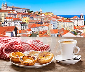 cup of coffee and plate of portuguese pastries - Pastel de nata  over Alfama district  lisbon  Portugal photo