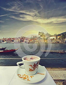 Cup of coffee with Porto riverside on a background