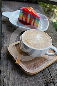 A cup of coffee with rainbow layer crepe cake