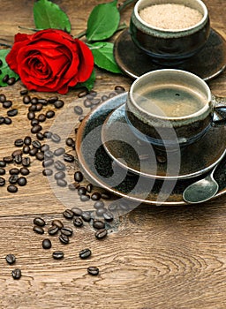 Cup of coffee and red rose flower. Festive table setting