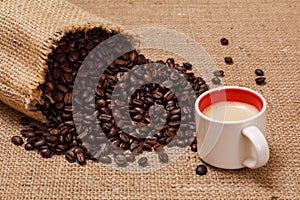 Cup of coffee and roasted coffee beans in a canvas sack