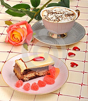 Cup of coffee, a rose and a cake