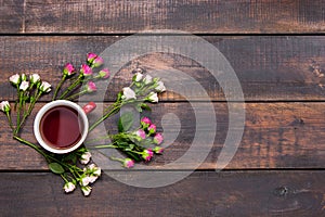 Cup of coffee with roses, top view