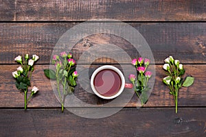 Cup of coffee with roses, top view