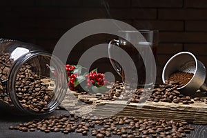 Cup of coffee on a rustic wood. Glass jar with coffee beans