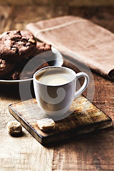 Cup of coffee on rustic wooden background.