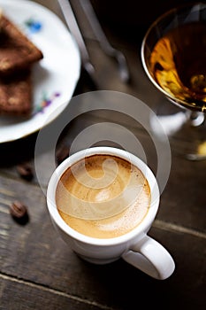 Cup of coffee on rustic wooden background.