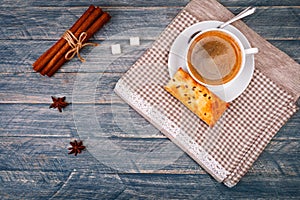 Cup of coffee on saucer with spoon. Vanilla sticks. Star anise and gray napkin