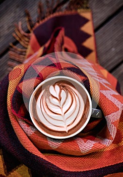 A cup of coffee with a scarf around