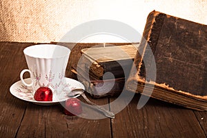 Cup of coffee, shokolad and stack of old books on the old wooden