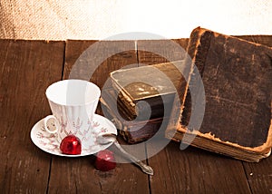 Cup of coffee, shokolad and stack of old books on the old wooden