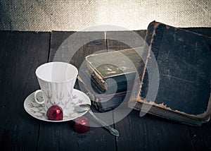 Cup of coffee, shokolad and stack of old books on the old wooden