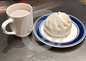 Cup of coffee and a siopao or dumpling. photo