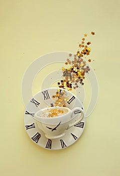 A cup of coffee on small plate on yellow background