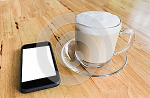 Cup of coffee and smart phone on wooden table