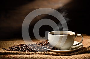 Cup of coffee with smoke and coffee beans on burlap sack on old wooden background