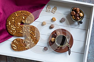 A cup of coffee and spiced bisquit on a tray photo