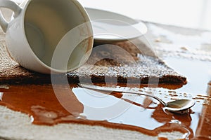 cup of coffee spilled on the tablecloth