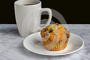 cup of coffee srved with chocolate chip muffin