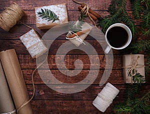 A cup of coffee stands on the table next to Christmas gifts