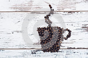 Cup of coffee with steam rising made of roasted coffee beans