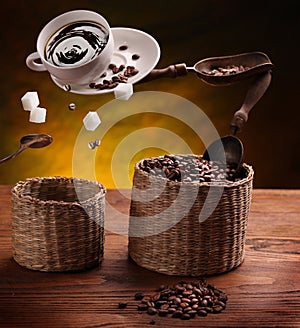 Cup of coffee, a sugar and coffee beans in the air .