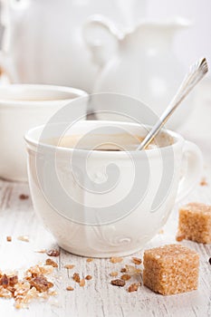 Cup of coffee with sugar cubs and milk jug