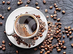 Cup of coffee surrounded by coffee beans. Top view.