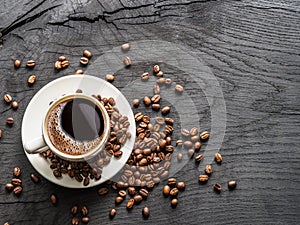 Cup of coffee surrounded by coffee beans. Top view.