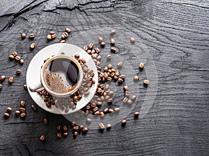 Cup of coffee surrounded by coffee beans. Top view