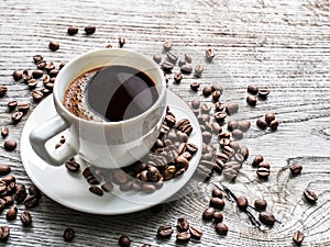 Cup of coffee surrounded by coffee beans. Top view.