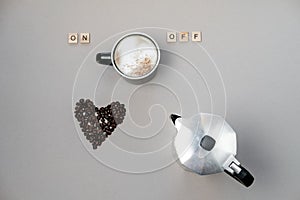 Cup of coffee switching on, grains and coffee pot on grey background. Top view, flat lay