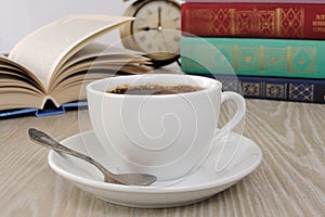 A cup of coffee on the table against the background of an open b