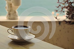 A Cup of coffee on the table in a cafe on the beach.