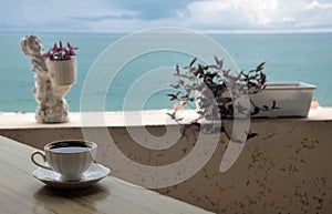 A Cup of coffee on the table in a cafe on the beach.