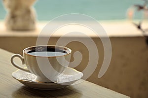 A Cup of coffee on the table in a cafe on the beach.