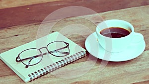 A cup of coffee on the table with newspaper-vintage filter effect