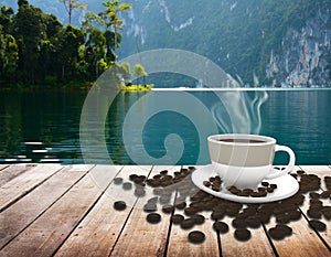 Cup with coffee on table over lake
