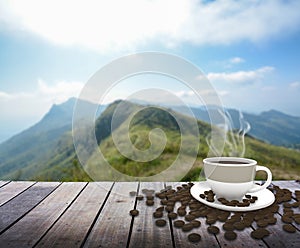 Cup with coffee on table over mountains